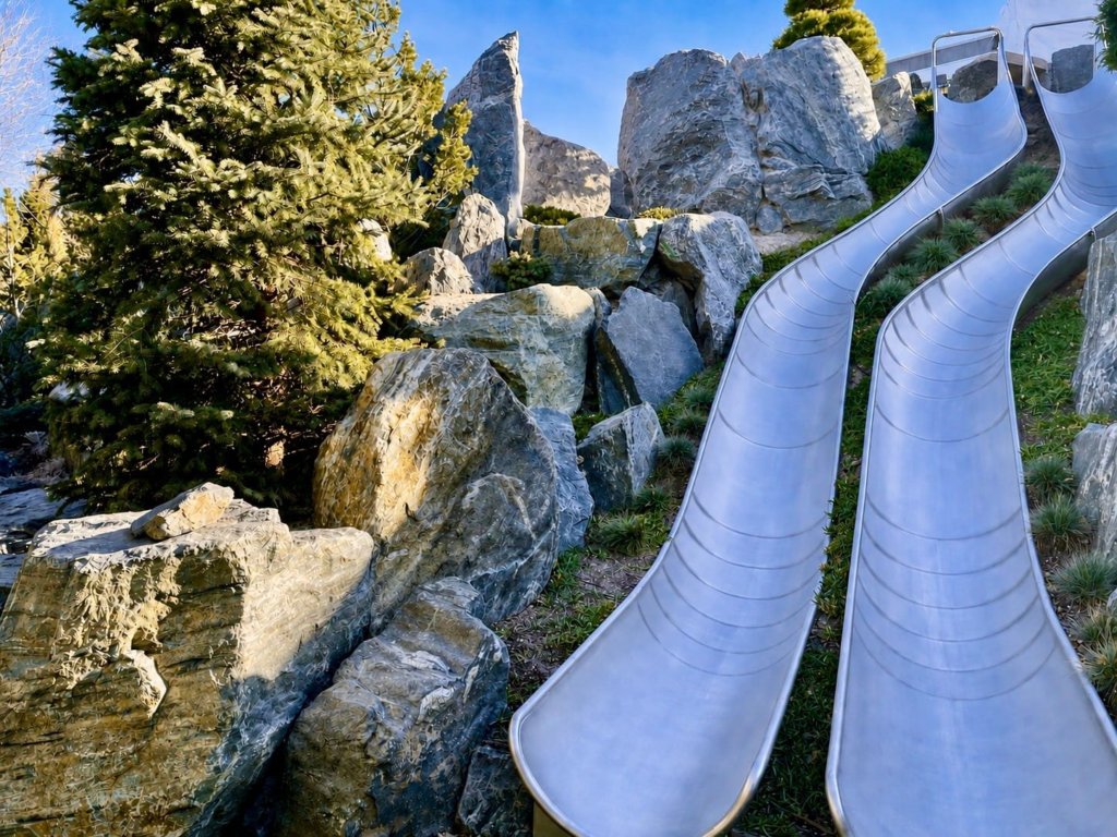 Landrec custom open slide: twin stainless steel slides set into a rocky hillside