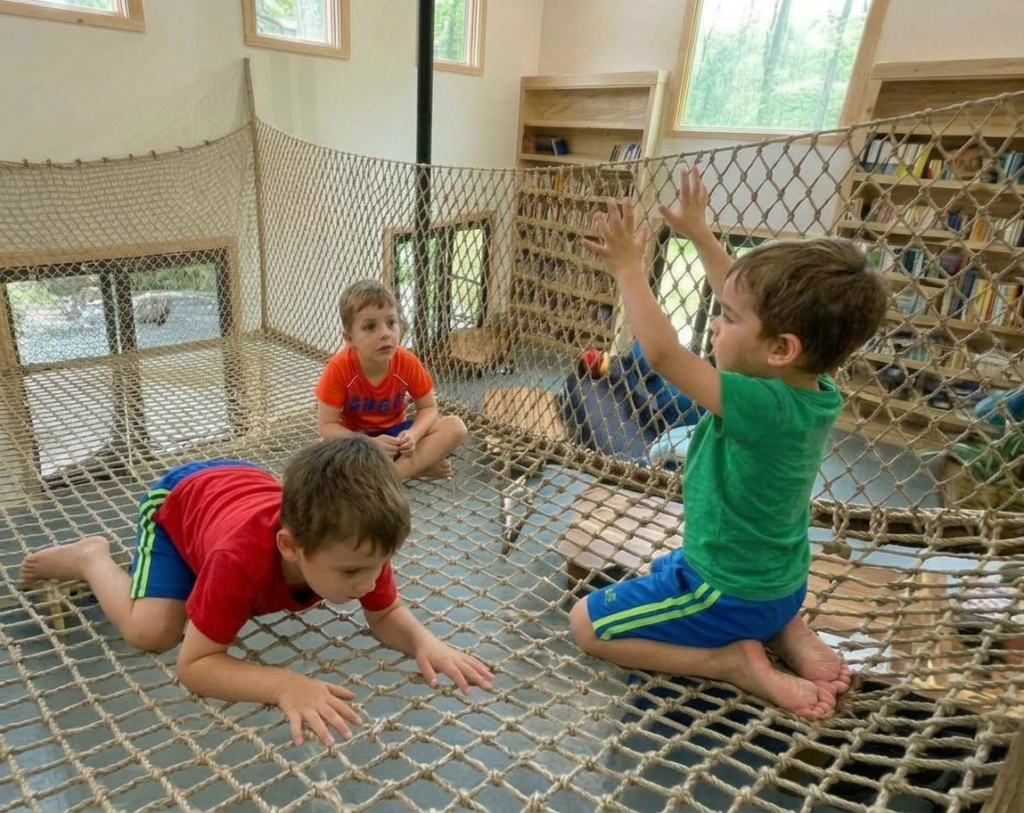 Kids playing on an indoor climbing net floor in a home library